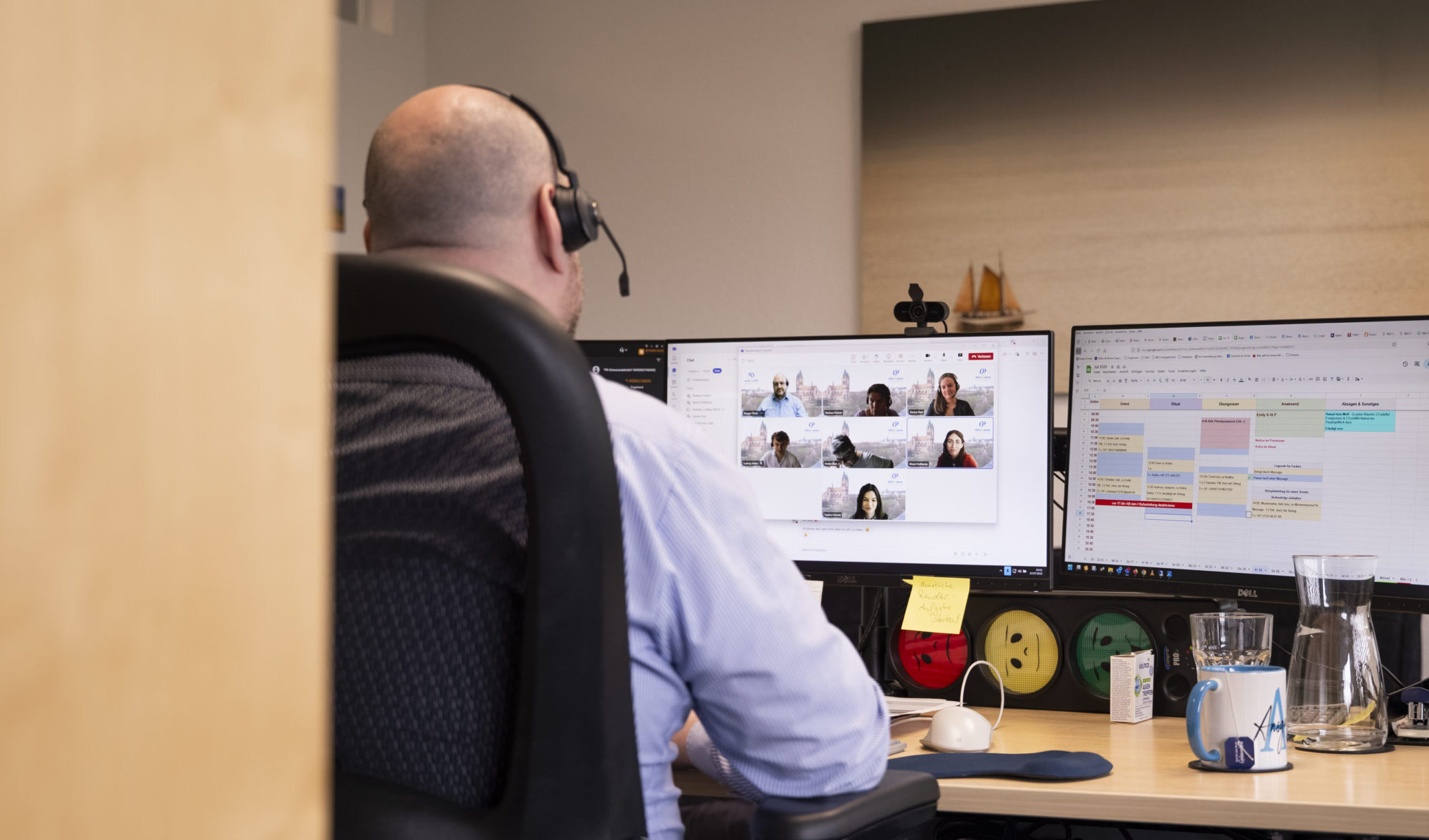 Ein Mitarbeiter von office & phone sitzt beim wöchentlichen Team-Meeting an seinem PC. Das Meeting findet in Hybridform statt.